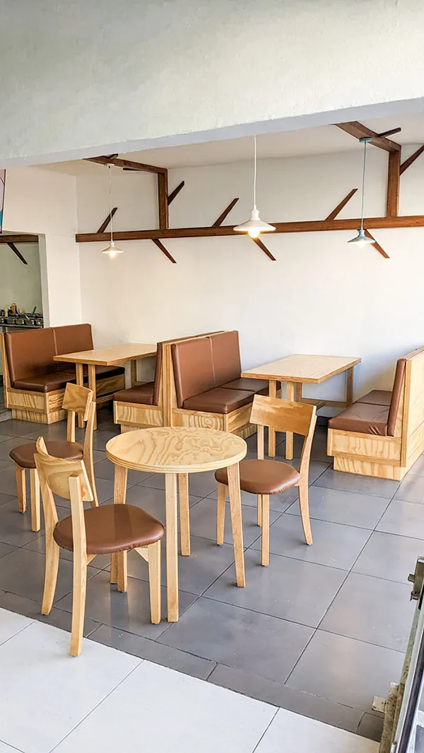 Square image of dining area with wooden tables and chairs