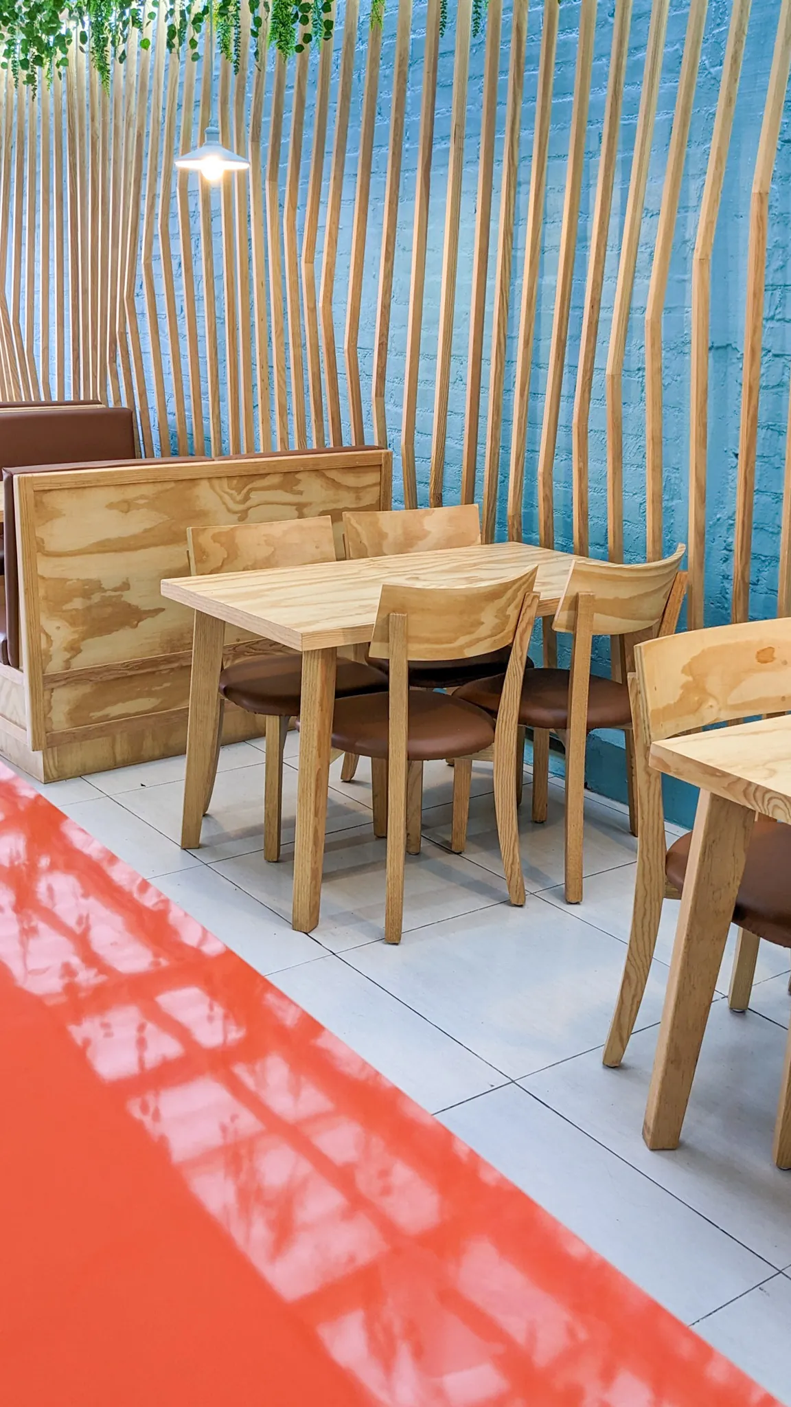 Square image of seating area with distinctive wooden slat wall design